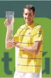  ?? AFP-Yonhap ?? John Isner poses with the Butch Buchholz trophy after defeating Alexander Zverev during the men’s final of the Miami Open at Crandon Park Tennis Center in Key Biscayne, Fla., Sunday.