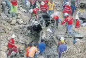  ?? AP ?? Rescuers remove a vehicle crushed by the landslide.