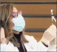  ?? Ned Gerard / Hearst Connecticu­t Media file photo ?? Gina Christakos fills a syringe with a COVID-19 vaccine at Hartford HealthCare’s mass vaccinatio­n clinic on the west campus of Sacred Heart University in Fairfield on March 10.