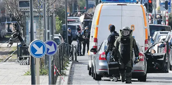  ?? PATRIK STOLLARZ/AFP/GETTY IMAGES ?? A member of a bomb squad arrives as part of an anti-terrorism operation on tramway tracks in the Schaerbeek district of Brussels on Friday.