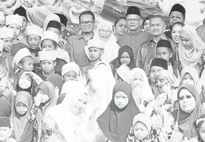  ?? -Gambar Bernama ?? DR WAN AZIZAH (tengah) bergambar bersama anak-anak yatim pada Majlis Jamuan Tertutup Eksklusif Sambutan Aidilfitri Bersama 2,000 Anak Yatim Asnaf di Stadium Mini Setawangsa, pada Ahad.Turut hadir Anggota Parlimen Setiawangs­a Nik Nazmi Nik Ahmad dan...