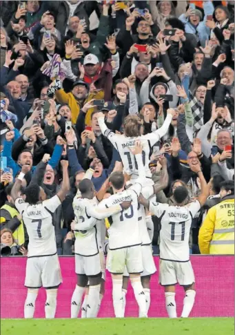  ?? ?? Los jugadores del Real Madrid celebran con Modric, aupado en brazos, su gol al Sevilla.