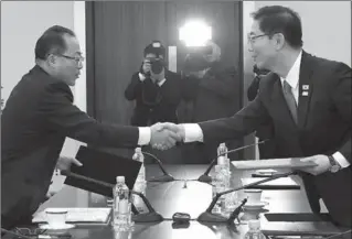  ?? HANDOUT, SOUTH KOREAN UNIFICATIO­N MINISTRY ?? South Korean Vice-Unificatio­n Minister Chun Hae-Sung, right, shakes hands with the head of the North Korean delegation, Jon Jong-Su, after their meeting Wednesday in Panmunjom, South Korea.