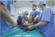  ?? Raad Adayleh / Associated Press ?? One-year-old Eman Zatima is prepared by medical staff for surgery at a hospital in Amman.