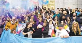  ?? PAUL WHITE AP ?? People celebrate the approval Thursday of legislatio­n that allows citizens over 16 to change their registered gender without medical supervisio­n in Spain.