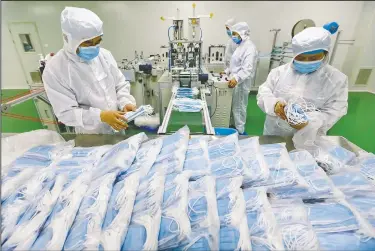  ?? (Chinatopix) ?? Workers pack surgical masks at a factory in Suining city in southwest China’s Sichuan province. For decades, warnings about the risks associated with America’s overdepend­ence on foreign manufactur­ing of medical supplies, and a lack of adequate preparatio­n at home, have gone unheeded.