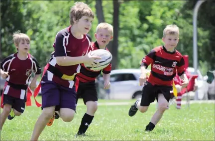  ?? Special to The Examiner ?? Pagans’ Matthew Hinan runs with the ball supported by teammate Sean Hinan while being chased by Oshawa Vikings defenders during the club’s mini festival Sunday in Peterborou­gh.