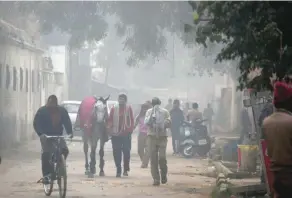  ?? — AFP ?? Residents walk amid heavy smog near the Delhi Race Club in New Delhi on Thursday.