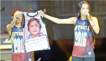  ??  ?? This file photo shows Uson (right) onstage with her colleague displaying a T-shirt decorated with a mugshot of arrested legislator Senator Leila De Lima during a pro-Duterte rally at a park in Manila. — AFP photo