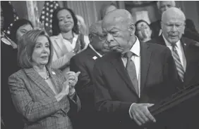  ?? BRENDAN SMIALOWSKI/AFP VIA GETTY IMAGES ?? House Speaker Nancy Pelosi joins the applause for Rep. John Lewis after the House passed a voting rights bill Dec. 6.