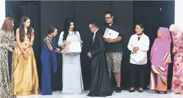  ??  ?? Sarawak Head of State’s wife Toh Puan Datuk Patinggi Raghad Kurdi Taib (fourth left) presenting the ‘Most Promising Sarawakian Designer 2017’ award to Aaron G. Von Jolly of Von Jolly Couture witnessed by (from left) Datin Nikki Lugun, Stephanie...