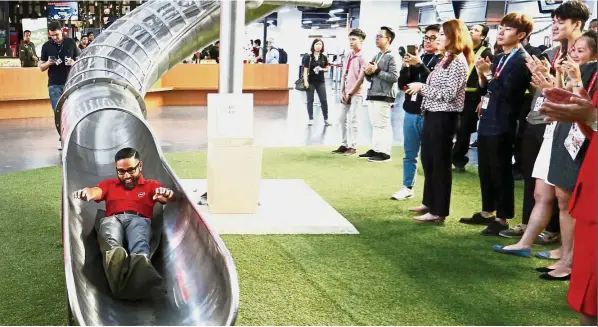  ?? — Reuters ?? Grand entrance: Riad sliding down a chute to make an entrance during a news conference at AirAsia headquarte­rs in Sepang. He will take over from Aireen Omar as the new CEO from Jan 10.