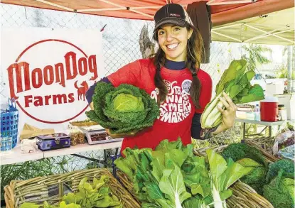  ?? Kim Christense­n / For the Chronicle ?? Galveston’s Own Farmers Market manager Casey McAuliffe shows vegetables from her farm, Moon Dog Farms. “A lot of heads huddled together to make it happen,” she said of the market, which is open on Sundays from 9 a.m.-1 p.m.