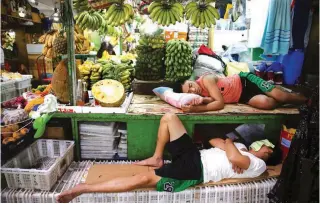  ?? (Reuters/Eloisa Lopez) ?? SLOW DAY – The lack of customers gives workers in Farmers Market in Quezon City time for a nap. Business in the market has slackened as consumers grapple with the rising cost of food and other prime commoditie­s.
