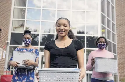  ?? Will Waldron / Times Union ?? Graduating Schenectad­y High School senior Kini-analysa Mccalmon, center, her sister, Zilya, 14, and mother, Thearse Mccalmon, have given out more than 400 masks to families in need.