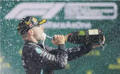  ?? Picture: AFP ?? TASTE OF SUCCESS. Mercedes’ Finnish driver Valtteri Bottas celebrates with champagne on the podium after winning the Austrian Formula One Grand Prix in Spielberg yesterday.