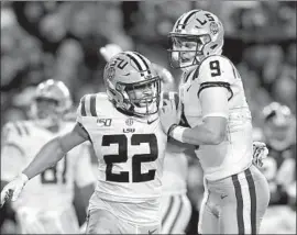  ?? Kevin C. Cox Getty Images ?? CLYDE EDWARDS-HELAIRE, left, and Joe Burrow celebrate during the second half of Louisiana State’s win over Alabama in Tuscaloosa on Saturday.