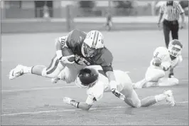  ??  ?? Briarcrest’s Hunter Bledsoe gets tackled by ECS’s Christian Lewis. Briarcrest missed an extrapoint attempt in overtime to seal the victory for the Eagles.