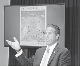  ??  ?? Gov. Andrew Cuomo displays a new poster on New York’s fight against coronaviru­s during a briefing Monday. DON POLLARD/OFFICE OF GOV. ANDREW CUOMO