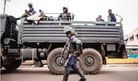  ?? — AFP ?? KINSHASA: A policeman walks in front of a police truck as the Congolese capital Kinshasa was gripped by a strike called ‘Villes mortes’ (Dead cities) in a protest over plans by the president to stay in power beyond the end of his term in December.