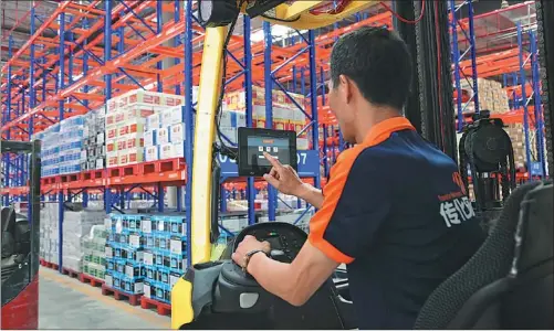  ?? PROVIDED TO CHINA DAILY ?? A Transfar Zhilian employee uses an internet app to sort deliveries in the company’s warehouse.
