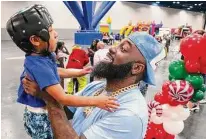  ?? ?? Trae tha Truth lifts and greets 4-year-old Jordan Kemp as the rapper and philanthro­pist arrives at the event.