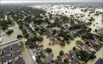  ?? The Associated Press ?? RECORD DOWNPOUR: Water from Addicks Reservoir flows into neighborho­ods as floodwater­s from Tropical Storm Harvey rise Tuesday in Houston. A pair of 70-year-old reservoir dams that protect downtown Houston and a levee in a suburban subdivisio­n began...