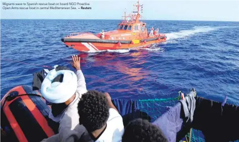  ?? — Reuters ?? Migrants wave to Spanish rescue boat on board NGO Proactiva Open Arms rescue boat in central Mediterran­ean Sea.