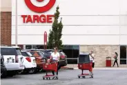  ?? AP PHOTO/BILL SIKES ?? Shoppers take purchases to their vehicle in the parking lot of a Target store in Marlboroug­h, Mass., on Tuesday, Aug. 4.
