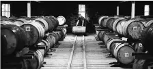  ??  ?? An employee moves a wooden cask of whisky at a distillery in Keith, UK