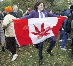  ?? COLE BURSTON / BLOOMBERG ?? An attendee holds a Canadian flag with a cannabis leaf on it Wednesday in Toronto during a celebratio­n of the legalizati­on of cannabis.