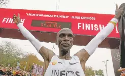  ?? RONALD ZAK/ASSOCIATED PRESS ?? Marathon runner Eliud Kipchoge of Kenya celebrates under the clock after crossing the finish line of the INEOS 1:59 Challenge in 1:59:40 on Saturday in Vienna. He is the first person to run a marathon under two hours, but the record isn’t official.