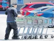  ?? JOE BURBANK/ORLANDO SENTINEL ?? A Publix employee wears a mask while retrieving shopping carts April 2 at the North Orlando Avenue store in Winter Park. Publix recently confirmed employees at three Orlando-area stores have tested positive for coronaviru­s.