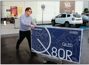  ?? (AP) ?? A man leaves a store with a flat screen on Black Friday in 2019 in Bayonne, southweste­rn France. The French government has postponed Black Friday this year.