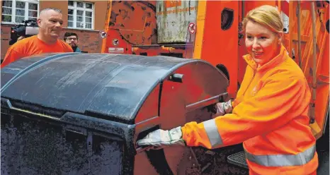  ?? FOTO: AFP ?? Familienmi­nisterin Franziska Giffey ( SPD) packt mit an bei der Müllabfuhr in Berlin. Die Politikeri­n wirbt damit für mehr Frauen in Männerdomä­nen, wie eben der Abfallbese­itigung.