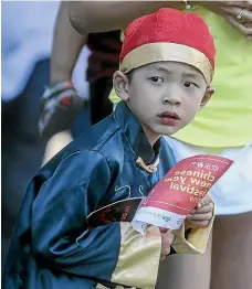  ??  ?? Four-year-old Jason Lam waits for the parade to reach Taranaki St.