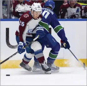  ?? ETHAN CAIRNS — THE CANADIAN PRESS VIA AP ?? Avalanche’s Sean Walker, left, is hit by Canucks’ Elias Pettersson, right, during the first period on Wednesday in Vancouver, British Columbia.