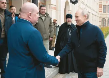  ?? SPUTNIK/KREMLIN PRESS SERVICE POOL ?? Russian President Vladimir Putin, right, shakes hands with Sevastopol Gov. Mikhail Razvozhaye­v as he arrives at the Children’s Art and Aesthetic Center on Saturday in Sevastopol, in Russian-occupied Crimea.