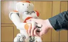  ??  ?? ROBOPRENUE­R: Nao Robot, designed to be a companion around the house, is seen shaking hands with a human in a mock business deal