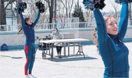  ?? PAUL CHIASSON THE CANADIAN PRESS ?? Pierrette Lalonde-Gosselin, 88, watches as Montreal Alouettes cheerleade­rs perform for seniors on the terrace of the residence Au Fil de l'eau in Montreal on Wednesday. Quebec and Ontario are still seeing hundreds of new COVID-19 cases every day.