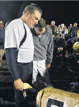  ??  ?? Pelham’s then-head coach Jim Morrell (left) and Greenville’s then-head coach Jeremy Williams join for a tearful mutual team prayer after the Patriots defeated Pelham 25-0 at Greenville High in November 2009.