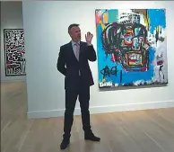  ?? AFP ?? A Sotheby’s official speaks about an untitled painting by Jean-Michel Basquiat, during a media preview in May 2017.