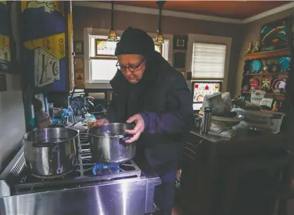  ?? Karen Warren / Staff photograph­er ?? Heights resident Bill Weinle, who had been without water and power, boils water on his stove. For many Houstonian­s, the boil water notice is another setback if they’re already lacking power and water.