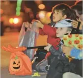  ?? JOHN RUCOSKY/THE TRIBUNE-DEMOCRAT ?? Trick-or-treaters collect candy last week in Johnstown, Pa. Some firms are trying to make it easier to recycle all those wrappers.
