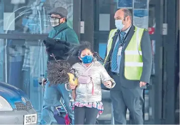  ??  ?? FREE TO GO: Chun Wong, left, and his daughter Kiernan leave the Doubletree by Hilton Hotel at Edinburgh Airport.