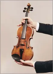  ?? ANDREW WHITE — THE NEW YORK TIMES ?? Jason Price, director of Tarisio auction company, holds the - da Vinci” Stradivari­us violin in Berlin, Germany, on April 30. Crafted in 1714 and played in “The Wizard of Oz” and other classic films, Toscha Seidel's Stradivari­us could sell for almost $20million at an online auction.