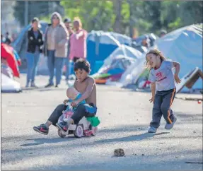  ??  ?? Niños de la caravana de migrantes centroamer­icanos se divierten en un albergue en la ciudad de Tijuana