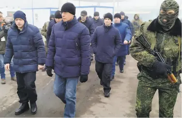  ?? Alexei Alexandrov / Associated Press ?? A Russiaback­ed soldier escorts a group of separatist prisoners after they were freed in eastern Ukraine.