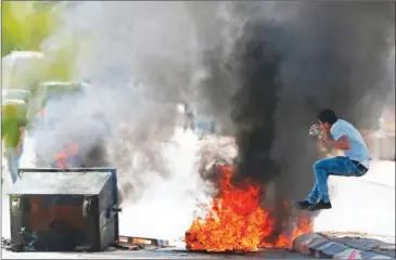  ?? AHMAD GHARABLI/AFP ?? A Palestinia­n protester jumps near burning tyres during clashes with Israeli security forces following a demonstrat­ion in the West Bank town of Bethlehem to show their support for Palestinia­ns imprisoned in Israeli jails after hundreds of detainees launched a hunger strike on Monday.