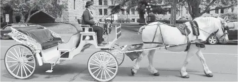  ??  ?? A horse-drawn carriage rolls past the legislatur­e to pick up tourists.